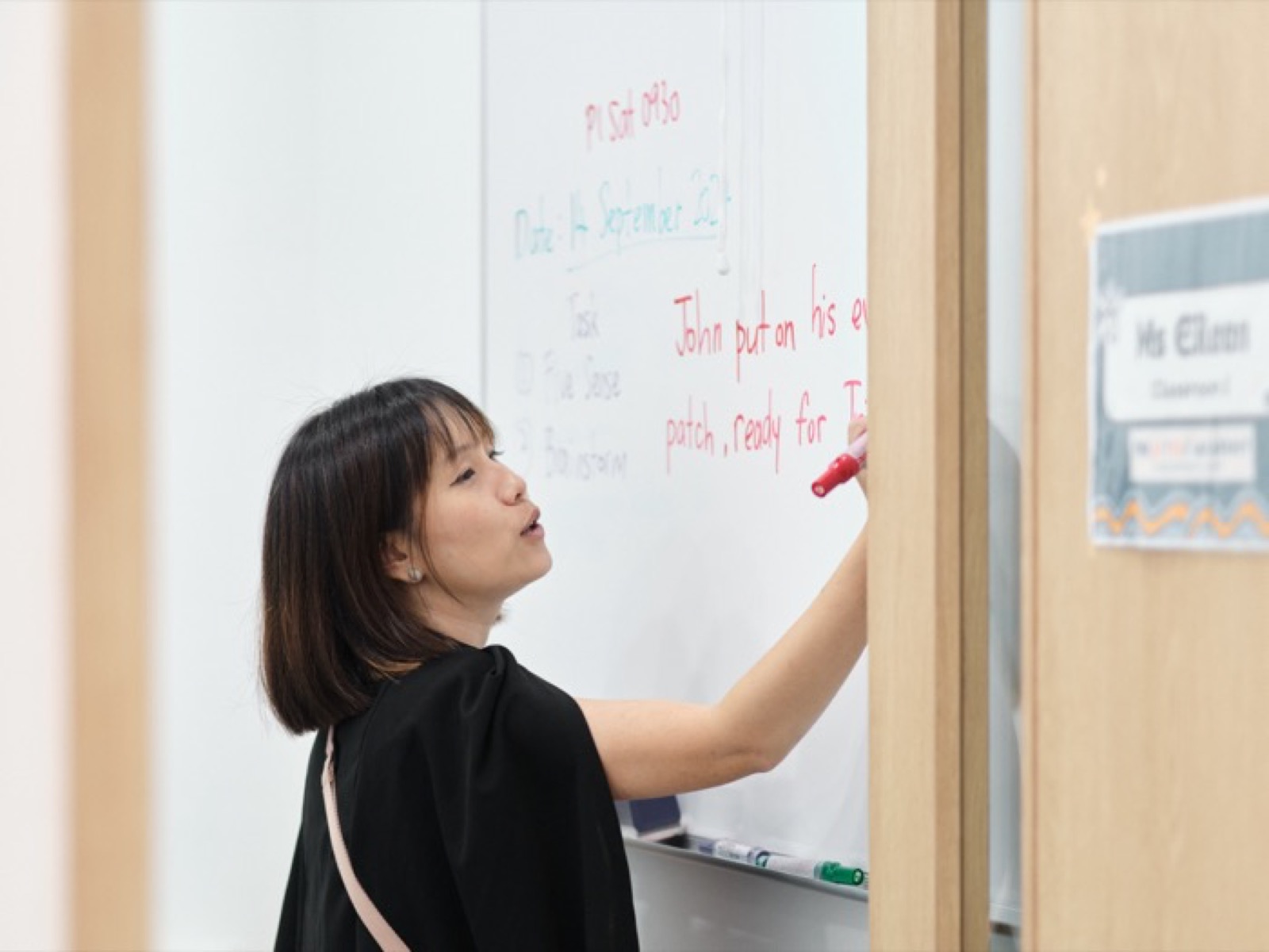 Ms Eileen writing on the whiteboard during a lesson