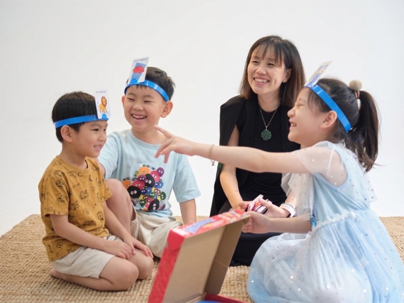 Ms Eileen laughing with three students during a classroom game