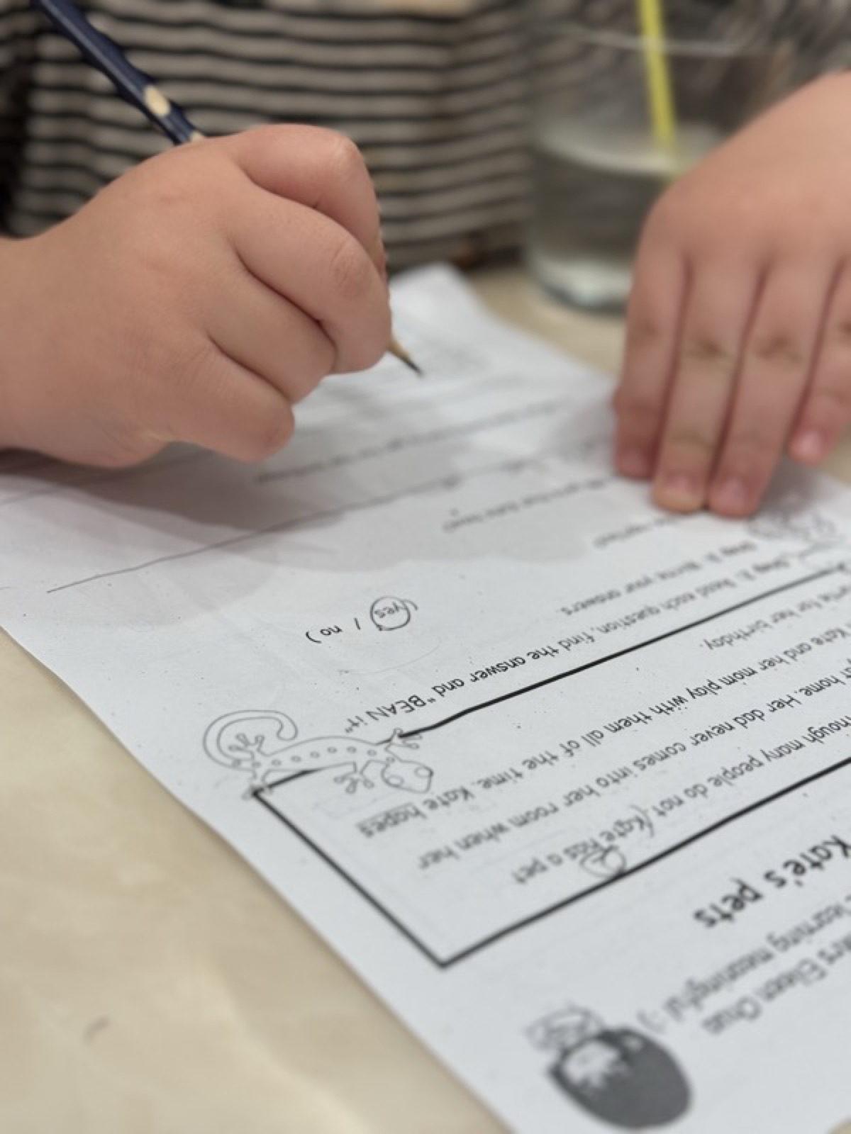 Student's hands writing on a worksheet
