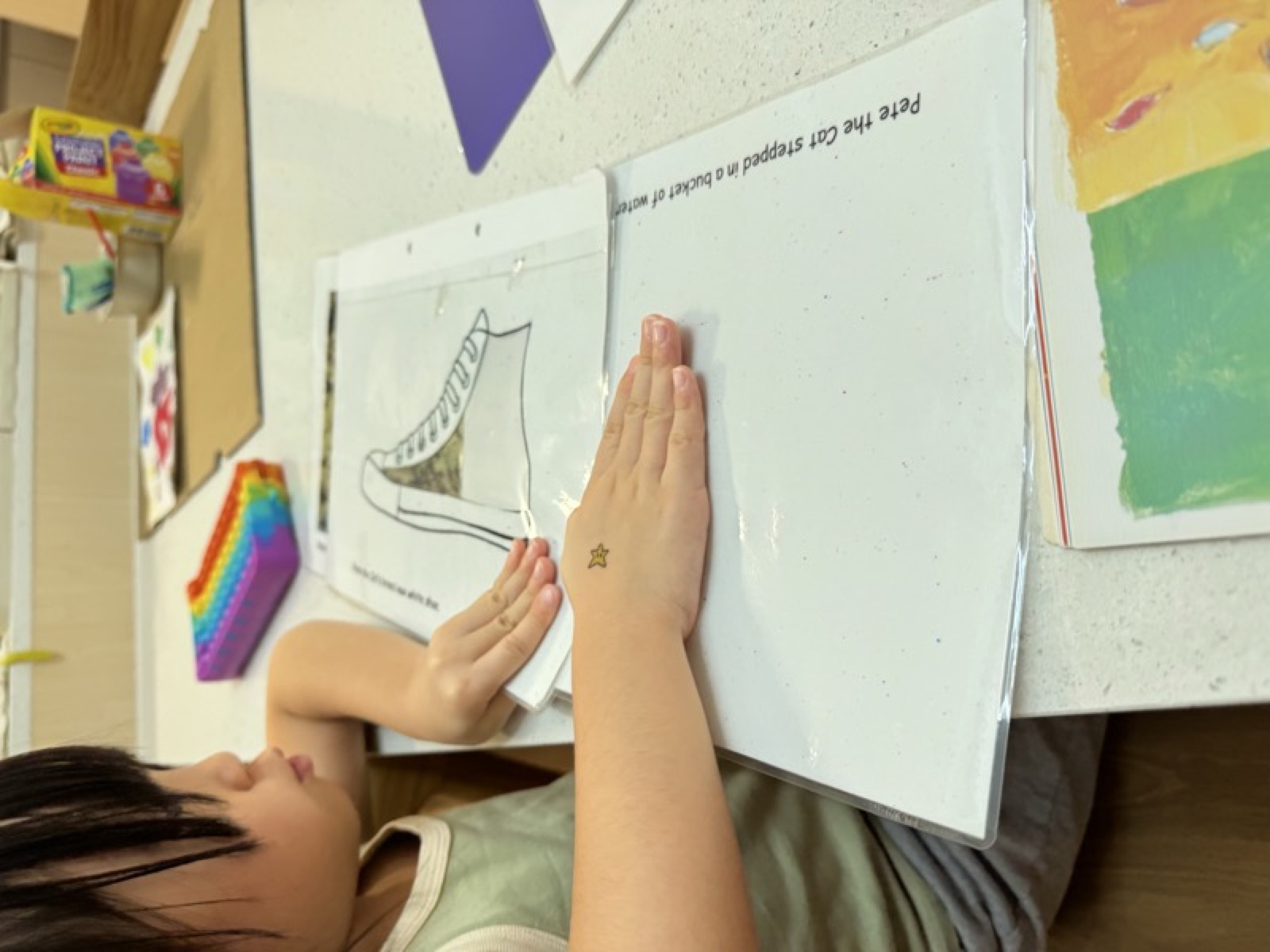 Student's hands working through a reading and lacing activity