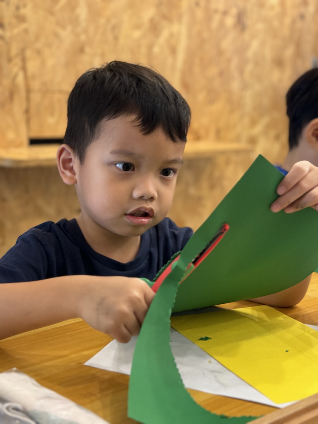 Student cutting coloured paper during a craft activity