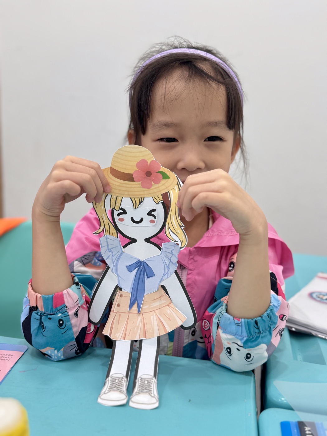 Student holding her handmade paper-doll character