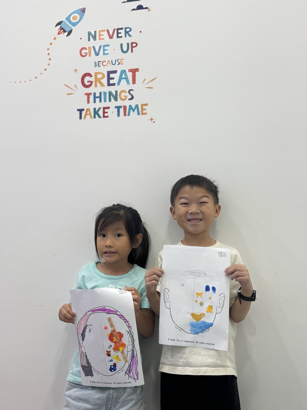 Students holding their self-portrait emotions artwork