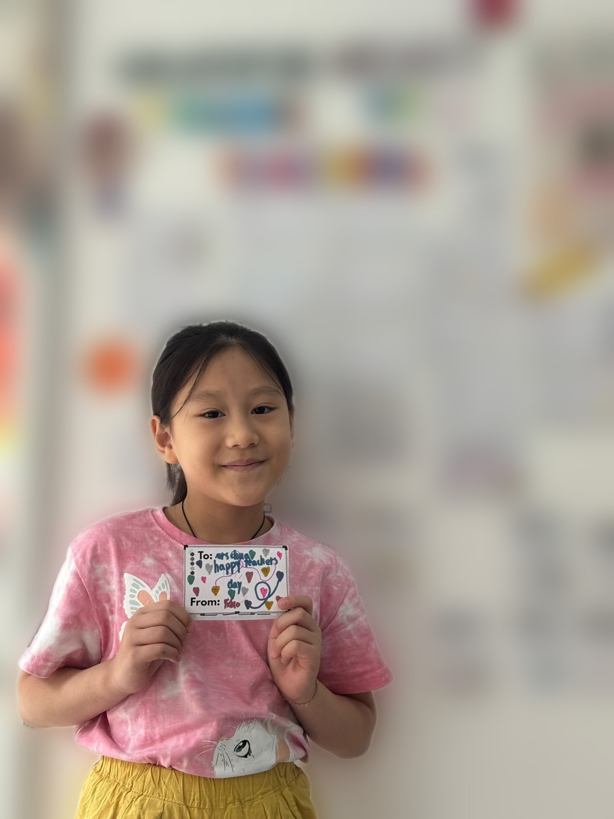 Student holding a thank-you card she made for her teacher