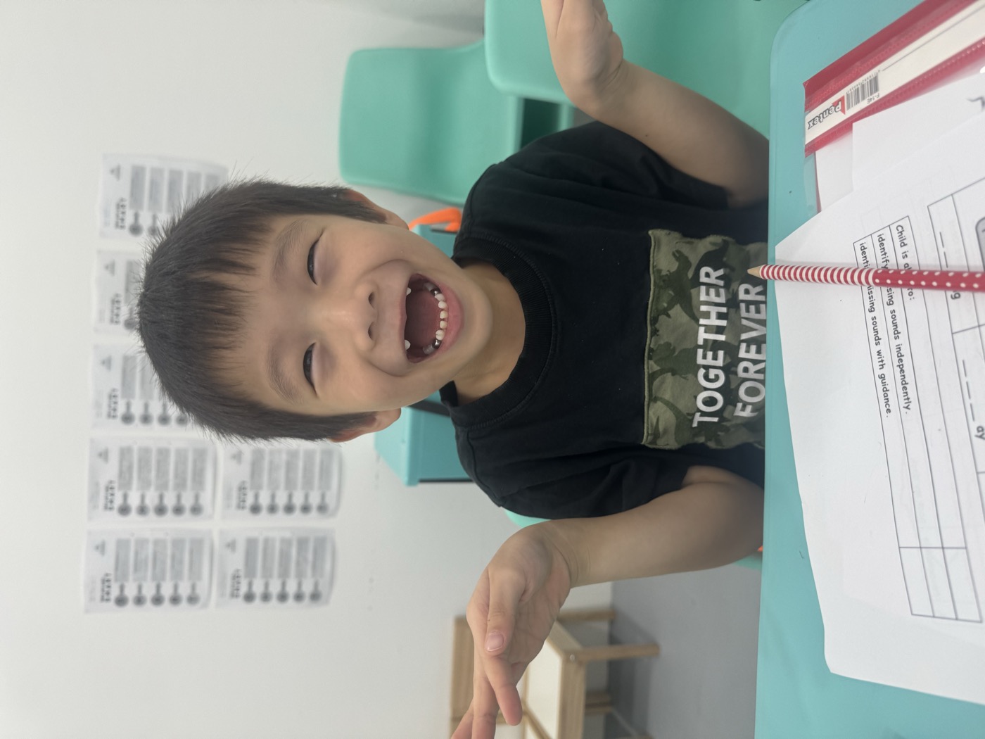 Student laughing at his desk during a phonics lesson