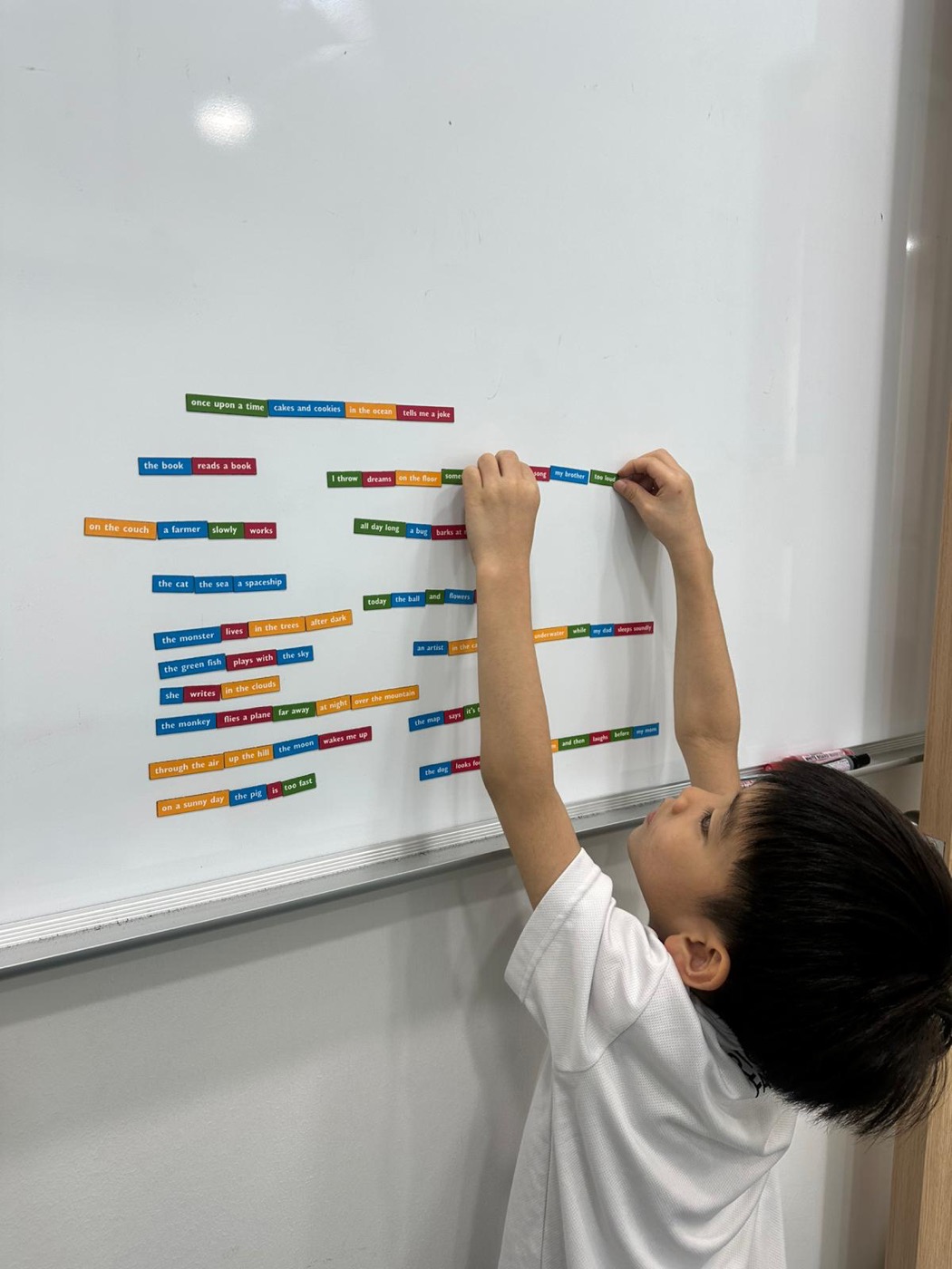 Student building sentences with word cards on the whiteboard
