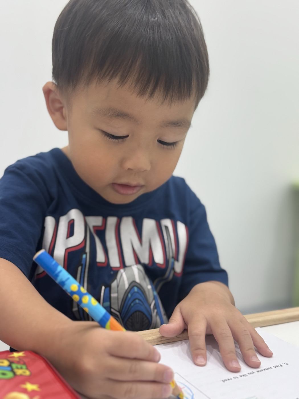 Young student concentrating while tracing letters